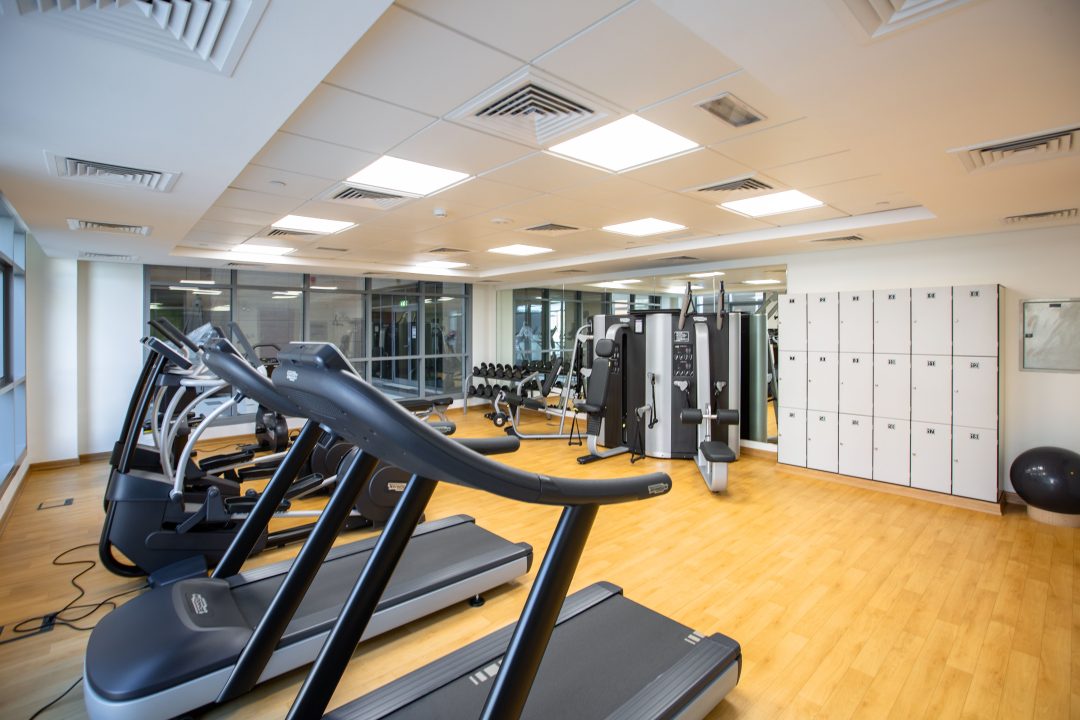 People participating in a group fitness class in a modern leisure centre exercise studio, promoting health, wellbeing and community engagement.